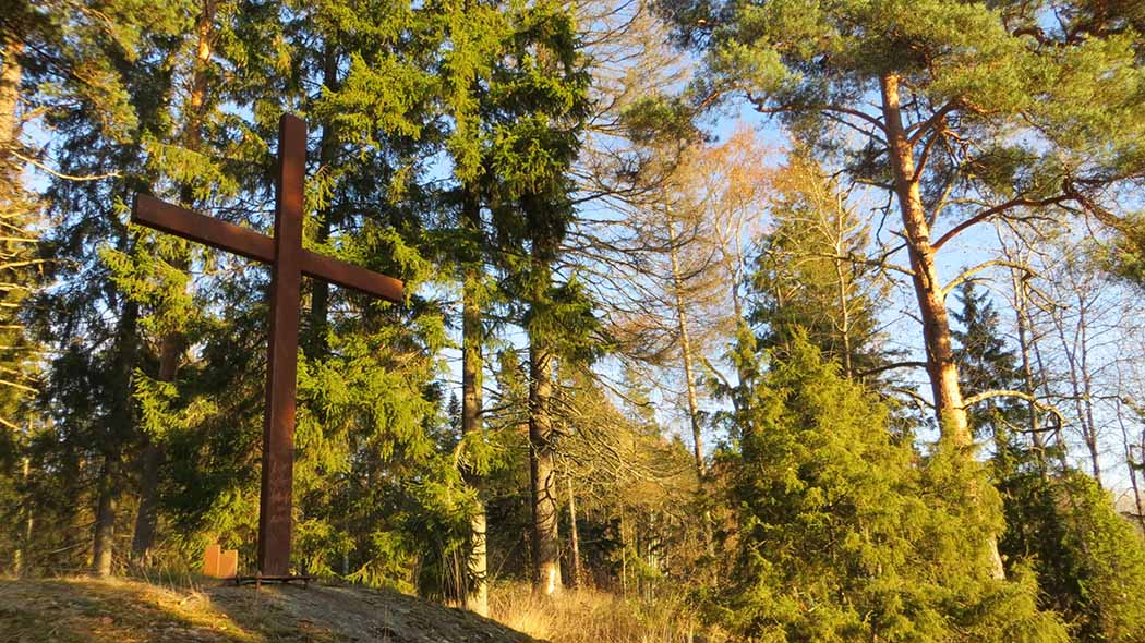 Ett stort träkors. I bakgrunden skog.