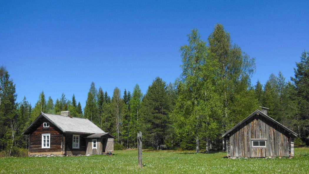 Latvavaara gård, på gården finns två byggnader. I bakgrunden finns skog.