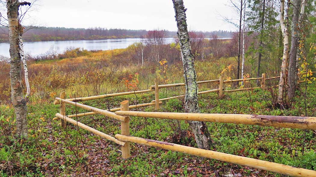 En igärdat område i förgrunden. I bakgrunden finns ett höstlikt sjölandskap.